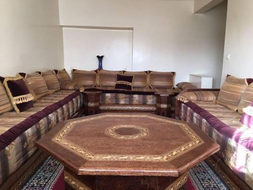 a living room with a couch with a table at Appartement spacieux à Agadir in Agadir
