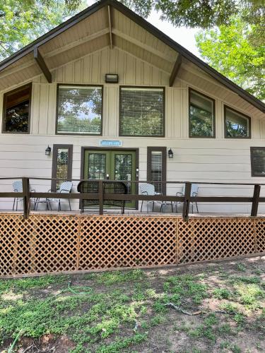 a house with tables and chairs in front of it at Hideaway - 3 BR Home with PRIVATE POOL on wooded lot in Montgomery