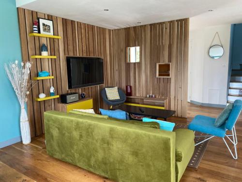 - un salon avec un canapé vert et un bureau dans l'établissement Maison contemporaine indépendante, proche plage et centre-ville, 4*, animaux acceptés, avec WIFI - FR-1-418-124, au Palais