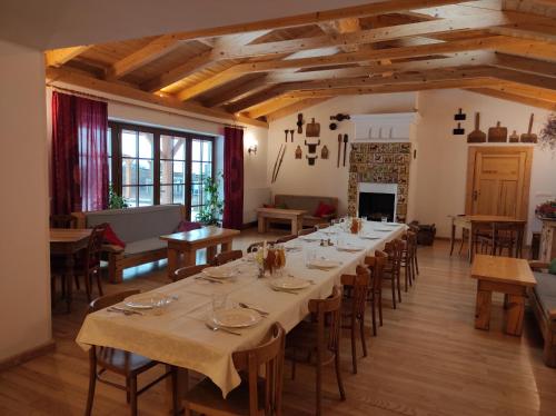 uma grande sala de jantar com uma mesa longa e cadeiras em Hajstra em Krempna