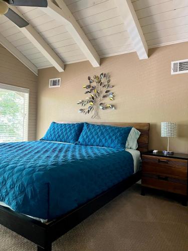 a bedroom with a blue bed with a blue comforter at Hideaway - 3 BR Home with PRIVATE POOL on wooded lot in Montgomery