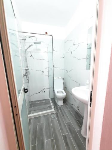ein Bad mit einem WC und einer Glasdusche in der Unterkunft Hotel Nacional Durres in Durrës