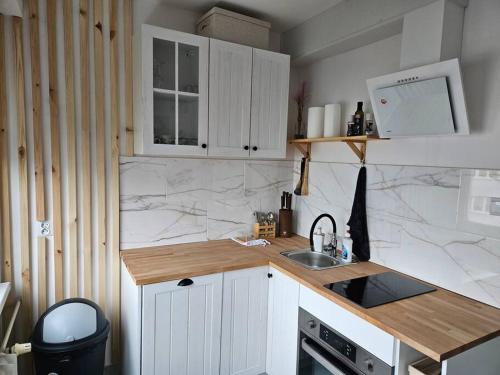 cocina con armarios blancos y encimera en ParkHome en Stalowa Wola