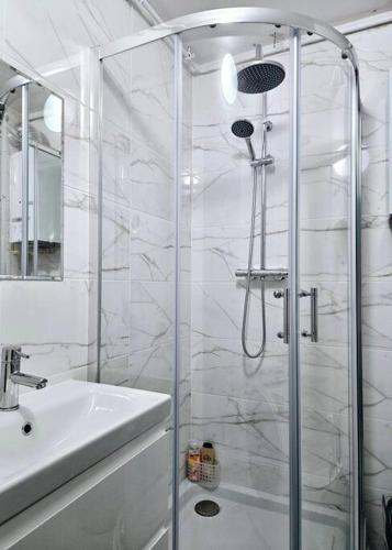 a white bathroom with a shower and a sink at ParkHome in Stalowa Wola