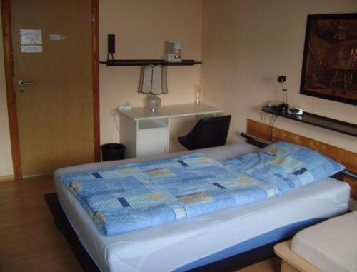 una camera da letto con un letto con una trapunta blu sopra di Gemütliches Zimmer 2 Et Inkl Parkplatz nach Verfügbarkeit a Essen
