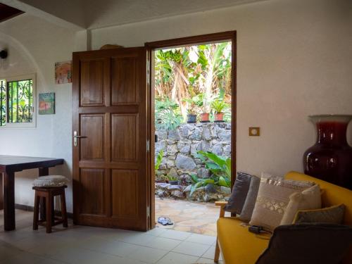 une porte ouverte sur un salon avec un canapé jaune dans l'établissement La petite Maison Bakov’, à Montjoly