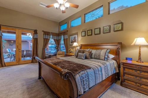 a bedroom with a bed and a dresser and windows at Quail Mountain Desert Resort: Heated Pool, Mt Vews, all BR's King & TV's, Hiking in Mesa