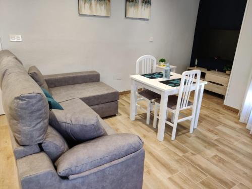 a living room with a couch and a table at Duerme a gusto - Tu habitación acogedora en Torredonjimeno in Torredonjimeno