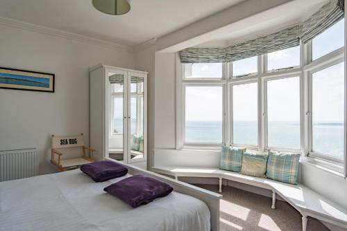 a bedroom with a bed and two windows at Seagulls by Bloom Stays in Folkestone