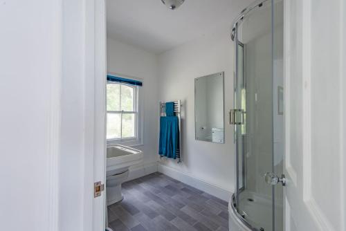 a bathroom with a shower and a toilet and a sink at Seagulls by Bloom Stays in Folkestone