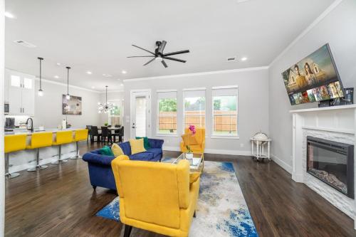 a living room with yellow chairs and a fireplace at Spectacular 4BRs Home in Downtown Dallas in Dallas