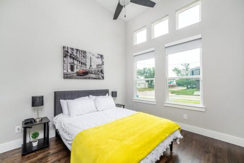 a bedroom with a bed with a yellow blanket at Spectacular 4BRs Home in Downtown Dallas in Dallas