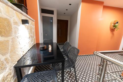 a balcony with a black table and chairs at Bella Vasilica Luxury Apartments in Parga