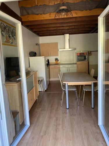 une cuisine avec une table et des chaises dans une pièce dans l'établissement appart. Gérardmer - Le Rep'Air, à Gérardmer