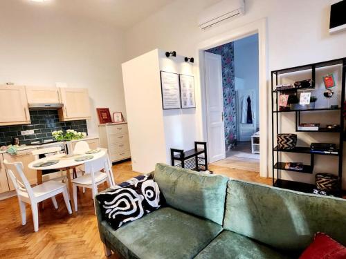 a living room with a green couch and a table at NEW LISTING IN THE HEART OF BUDAPEST Apartment Kamilla in Budapest