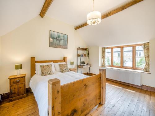 a bedroom with a large wooden bed and a window at Derwen Deg Fawr in Llanfair-Dyffryn-Clwyd