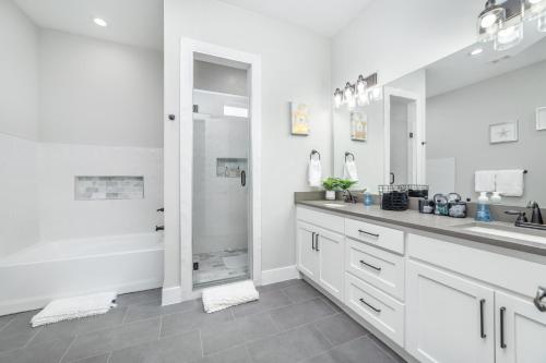 a white bathroom with a sink and a shower at Spectacular 4BRs Home in Downtown Dallas in Dallas