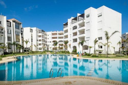 a large swimming pool in front of a building at Appartement Assilah marina golf in Asilah