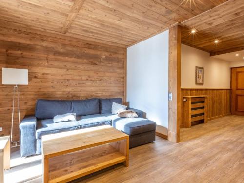 - un salon avec un canapé bleu et des murs en bois dans l'établissement Charmant 4 pièces en centre village, proche pistes - 8 pers, Wifi, parking, balcon, animaux acceptés - FR-1-437-48, à La Clusaz