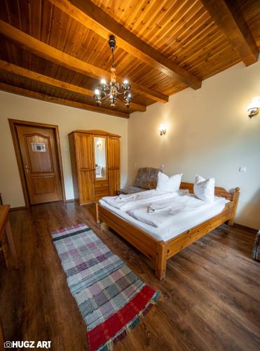 a bedroom with a bed and a wooden ceiling at Pensiunea Flora in Băile Tuşnad