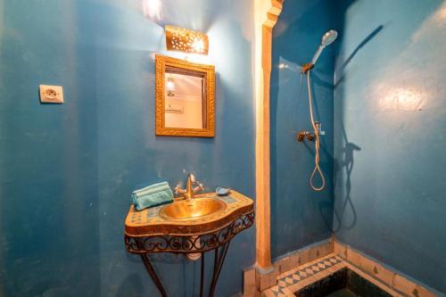 een blauwe badkamer met een wastafel en een douche bij Riad Résidence Al Qaria Assiyahia Riad 22 in Marrakesh