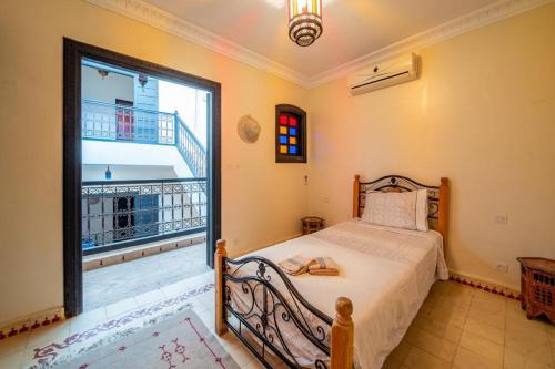 een slaapkamer met een bed en een groot raam bij Riad Résidence Al Qaria Assiyahia Riad 22 in Marrakesh
