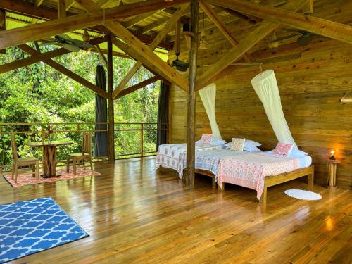 a bedroom with two beds in a wooden cabin at Casa Cayuco Eco-Adventure Lodge in Bocas del Toro