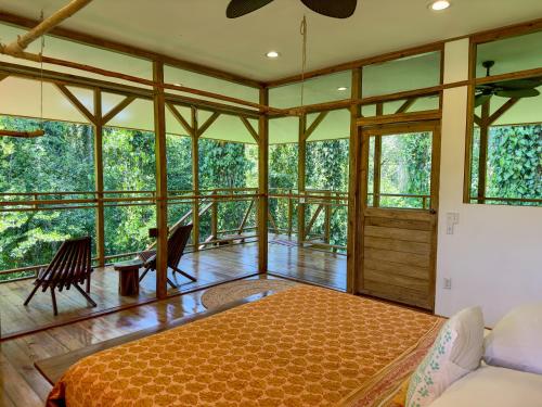 a room with a bed and some windows at Casa Cayuco Eco-Adventure Lodge in Bocas del Toro