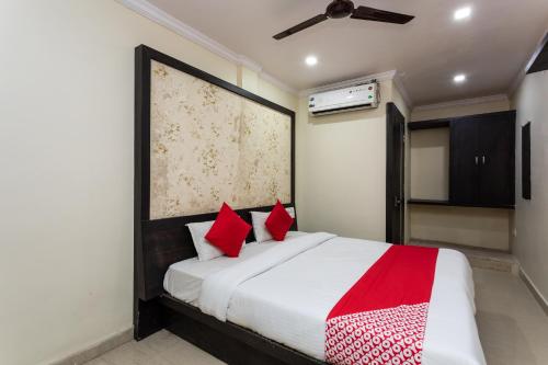 a bedroom with a large bed with red pillows at OYO Sun Palace in Jabalpur