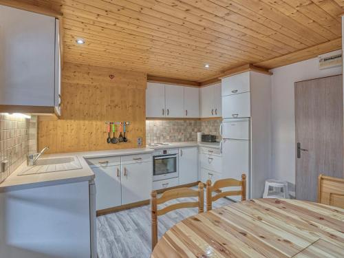 une cuisine avec des appareils blancs et un plafond en bois dans l'établissement Appartement Confort 2 Pièces avec Balcons, à 300m du Centre de Megève et Télécabine - FR-1-453-92, à Megève