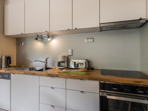 une cuisine avec des armoires blanches et un comptoir en bois dans l'établissement Studio Confortable avec Balcon, Centre de Megève, Parking, Ascenseur - FR-1-453-110, à Megève