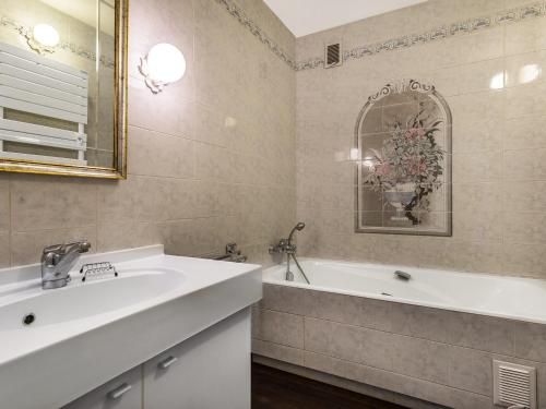 une salle de bain avec un lavabo, une baignoire et un miroir dans l'établissement Studio Confortable avec Balcon, Centre de Megève, Parking, Ascenseur - FR-1-453-110, à Megève