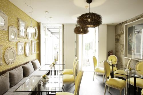 a dining room with yellow chairs and tables at In Porto Gallery Guesthouse in Porto