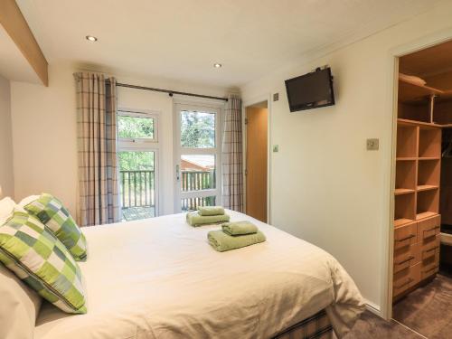 a bedroom with a bed with two green pillows on it at Forest Pines Lodge in Bowness-on-Windermere