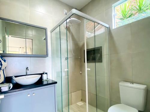 y baño con ducha, aseo y lavamanos. en Pousada Vila de Monaco, en Penha