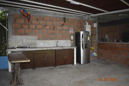 a kitchen with a refrigerator and a brick wall at Casa Campestre El Encanto in Trujillo