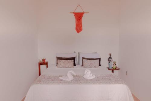 a white bed with two white swans on it at Recanto da Tuca in Socorro