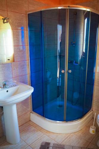 a bathroom with a shower and a sink at Pensiunea Riffelt in Bran