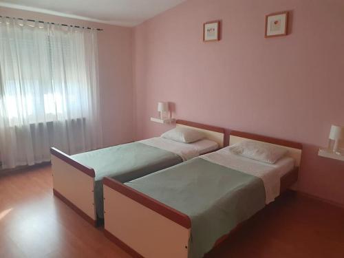 a bedroom with two beds and a window at Apartment Neli in Polača