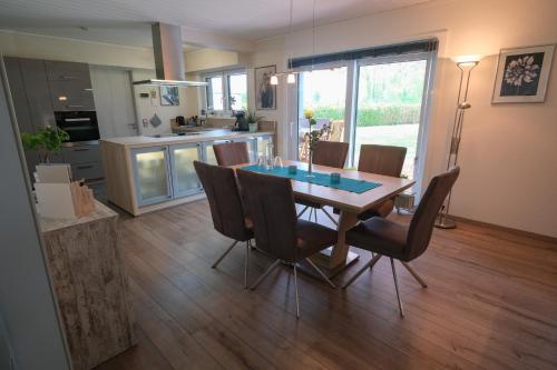 Una cocina y un comedor con mesa y sillas. en Casa alla Torre, en Vollersode