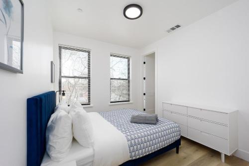 um quarto branco com uma cama e 2 janelas em New Build 3 Bed Entire Condo em Sacramento