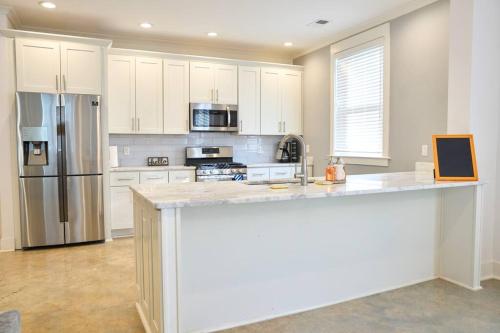 a kitchen with white cabinets and a large counter top at Modern Midtown home with 3 king beds in Memphis
