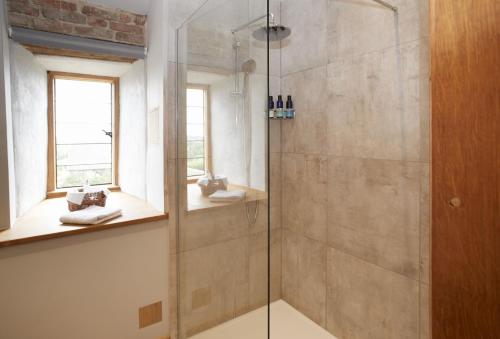 a bathroom with a shower with a glass door at The Dovecote in Pauntley
