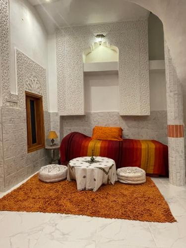 a bedroom with a bed and a table with two seats at DAR ALKATIB MEKNES in Meknès