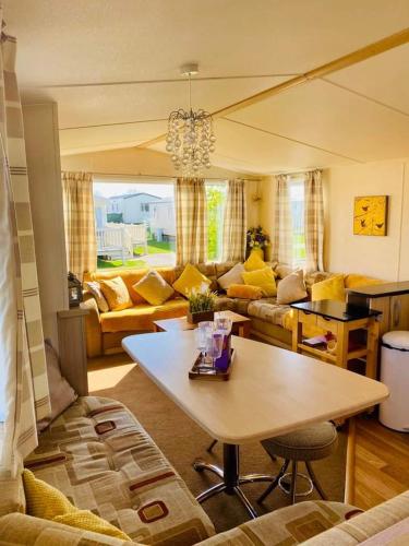 a living room with a table and a couch at Hot tub breaks Lancaster Cresent tattershall lakes in Lincoln