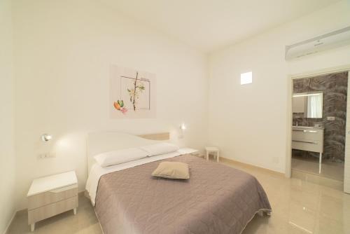 a white bedroom with a bed and a sink at B&B MANDORLO BIANCO in Avola