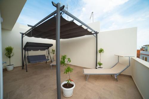 a black canopy on a balcony with potted plants at B&B MANDORLO BIANCO in Avola