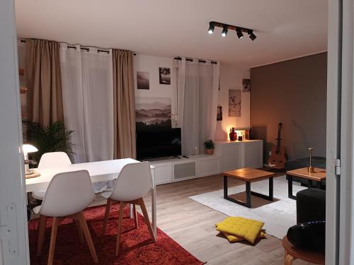 a living room with a white table and a television at Stylish 1-bedroom flat with beautiful terrace , for a cosy Retreat in Strasbourg