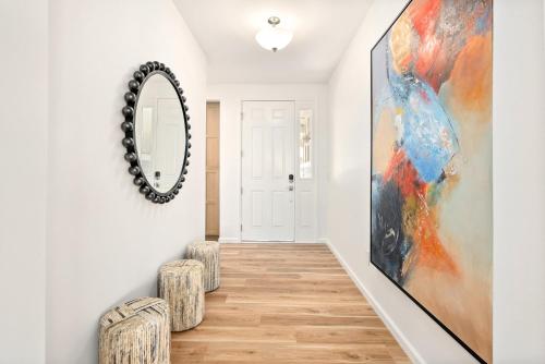 a hallway with a mirror and two stools at @ Marbella Lane - Mesmerizing Ocean + MT Views in Waianae
