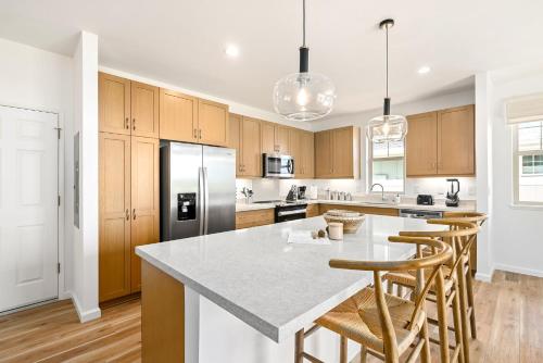 a kitchen with wooden cabinets and a large island with bar stools at @ Marbella Lane - Mesmerizing Ocean + MT Views in Waianae